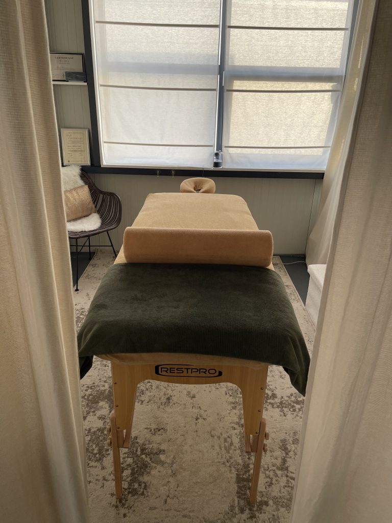 Rustige, lichte behandelruimte van Tamara Ontspant in Hoofddorp met massagetafel en planten